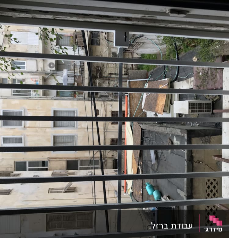 סורגי חלון עם נוף של בניינים ברקע